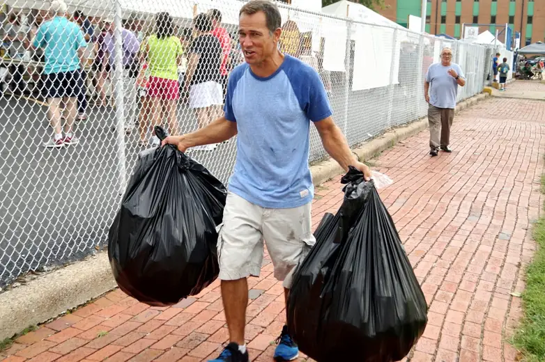 Volunteer carrying trash bags during Oktoberfest cleanup